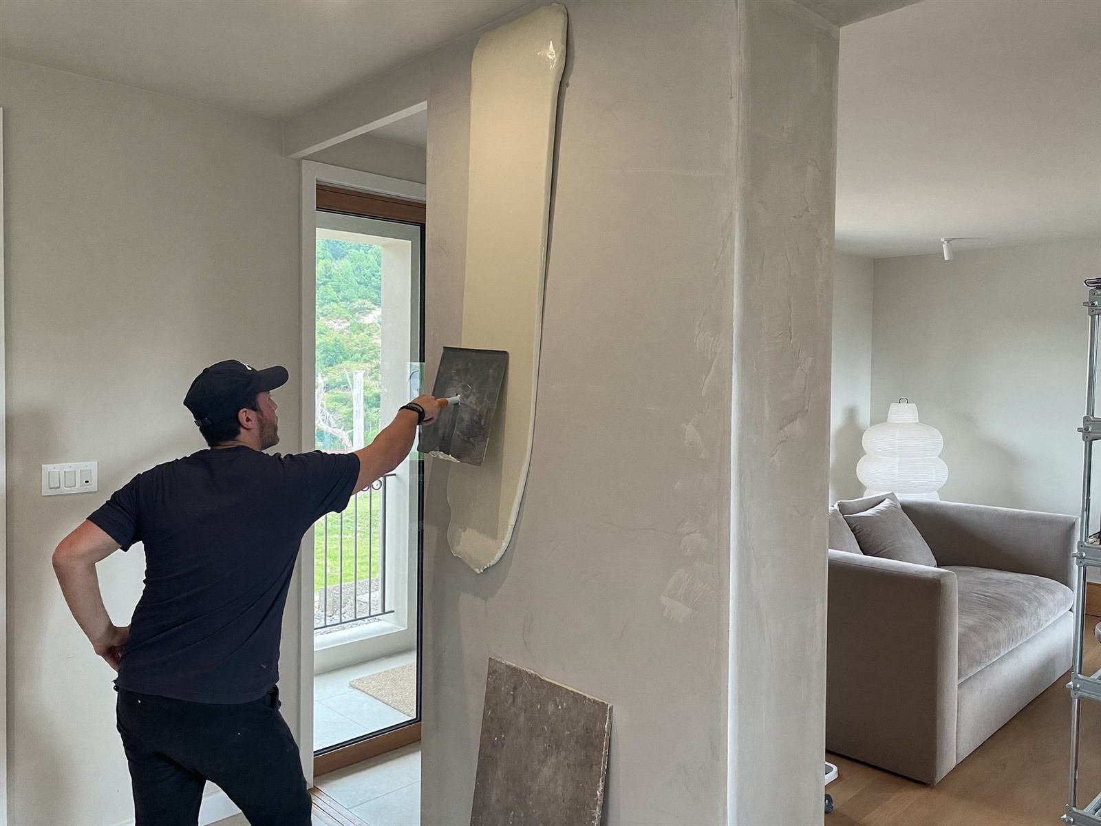 Handwerker verspachtelt eine Innenwand mit einer Traufel